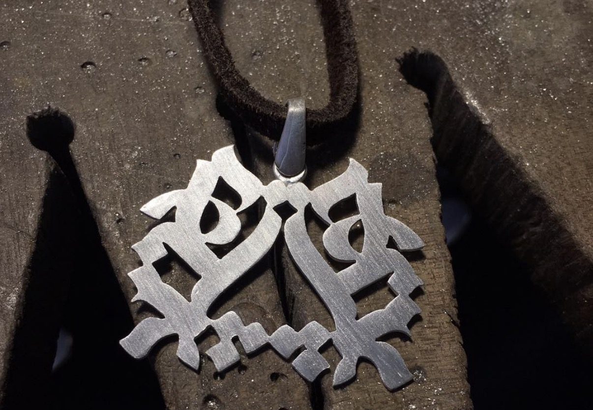 A handmade silversmithing piece in process: cut, filed, and soldered metal.